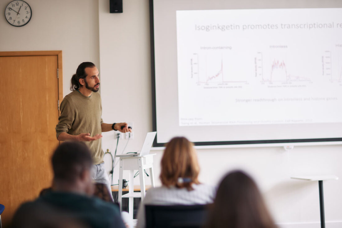 scientist presents a powerpoint while others watch on