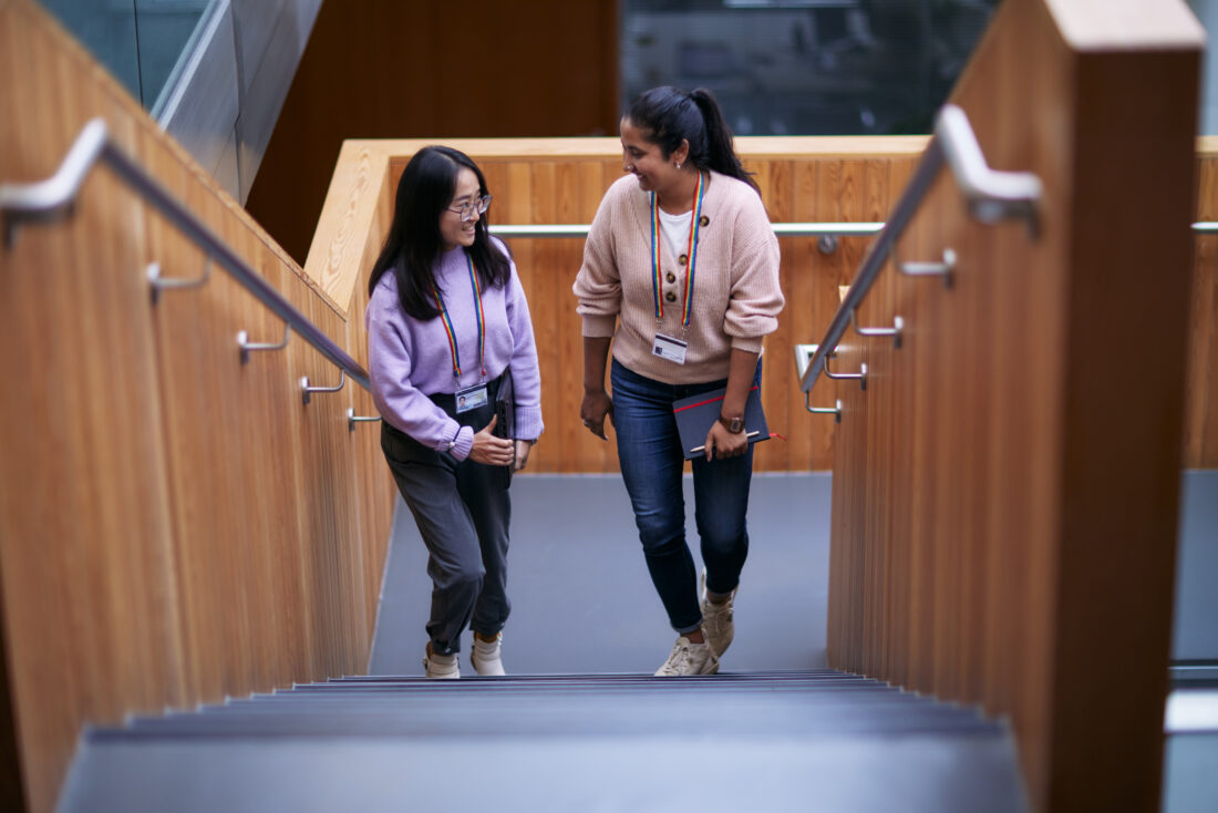two scientists chat while walking up the stairs