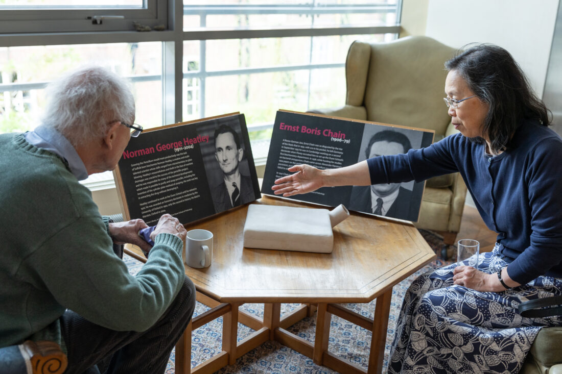Two people chat close to a display of history artefacts