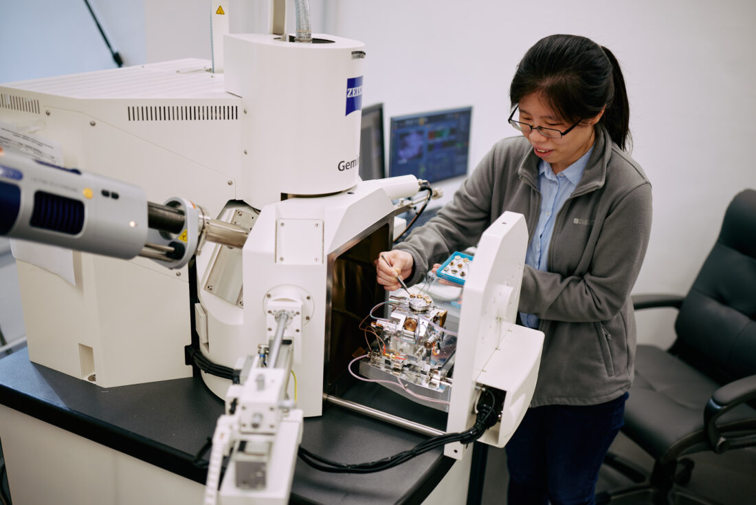 Scientist places samples in an electron microscope