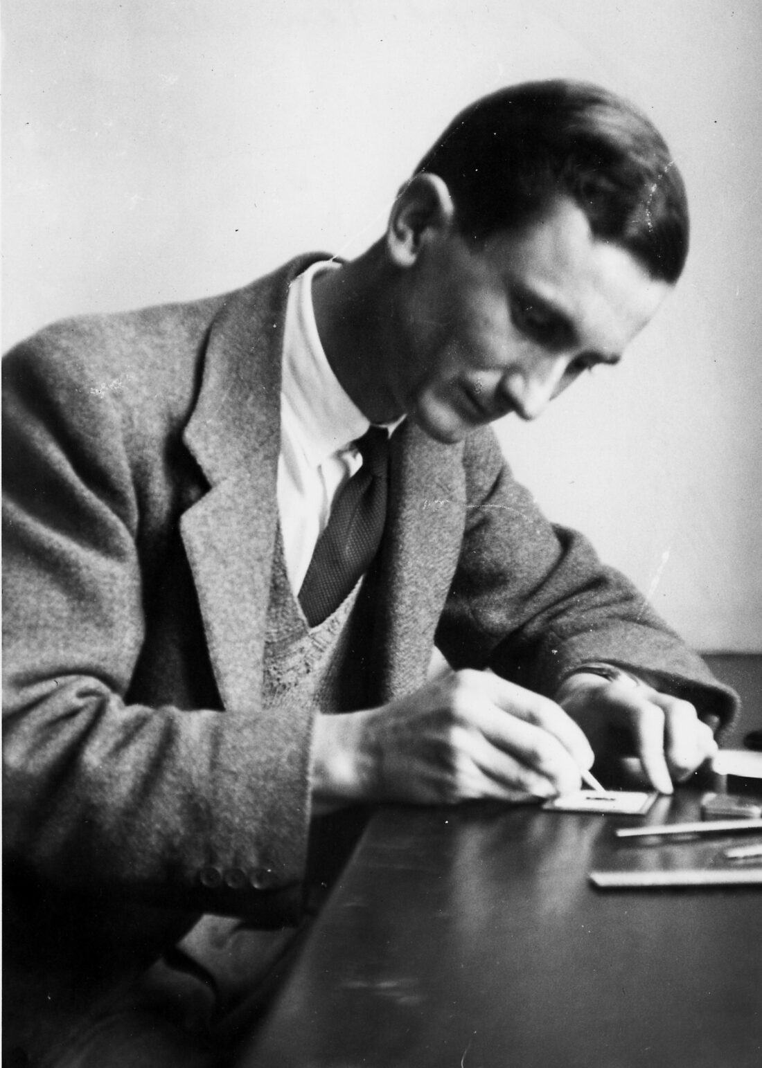 Photograph of Norman Heatley looking at a sample in the laboratory