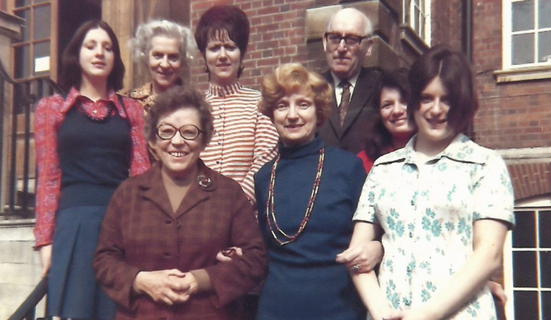 Group of support staff stood on steps outside the Dunn School